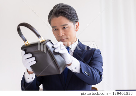 現場購買：一名男子正在評估一個包 129401833