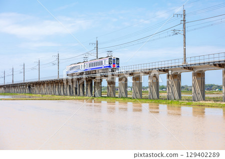 【北北線】在稻田環繞的高架軌道上行駛的普通列車 129402289