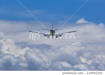 一架飛機在夏日雲彩的映襯下起飛和降落 129402293