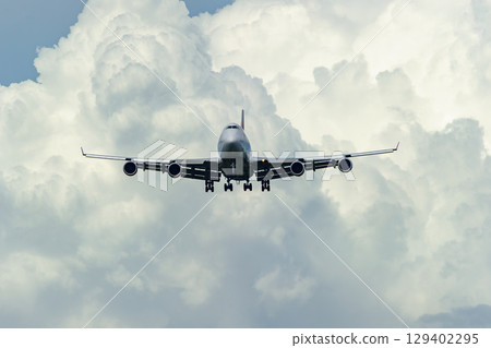 An airplane taking off and landing with summer clouds in the background An airplane taking off and landing with summer clouds in the background 129402295