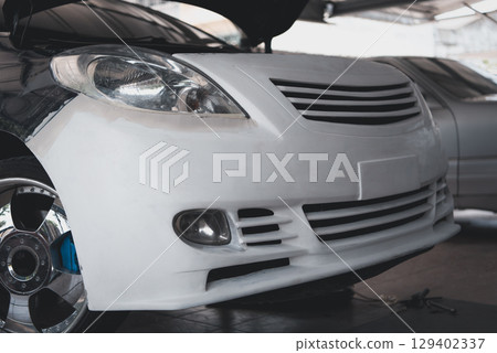 Checking car body work fiber bumper at car garage 129402337