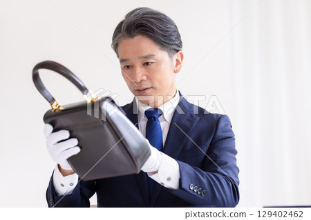 On-site purchase: A man assessing a bag On-site purchase: A man assessing a bag 129402462