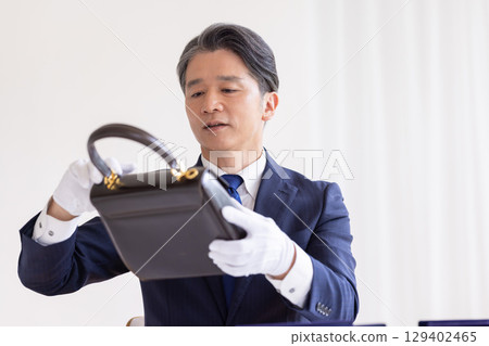 On-site purchase: A man assessing a bag 129402465