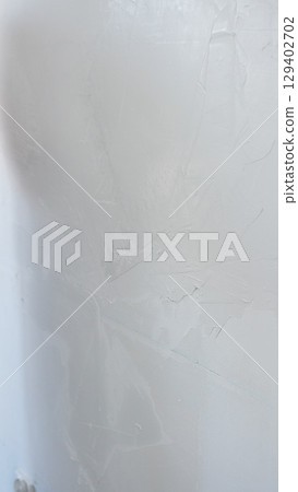 The wall is waiting to be using a finishing trowel to carefully apply plaster, demonstrating expertise in home renovation 129402702