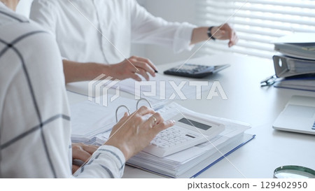 Close up of a calculator on financial documents, with an accountant hands working with, finance, and tax preparation. Audit and taxes in business 129402950