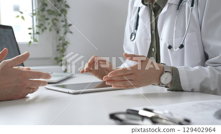 Doctor using digital tablet to show test results to a patient during a medical consultation in hospital office, healthcare and technology concept. Medicine and health care concept Doctor using digital tablet to show test results to a patient during a medical consultation in hospital office, healthcare and technology concept. Medicine and health care concept 129402964