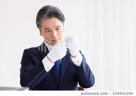 On-site purchase: A man assessing precious metals 129403294