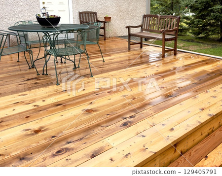 wet wooden patio with garden furniture wet wooden patio with garden furniture 129405791