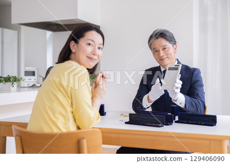 On-site purchase: A housewife having her items appraised at home 129406090