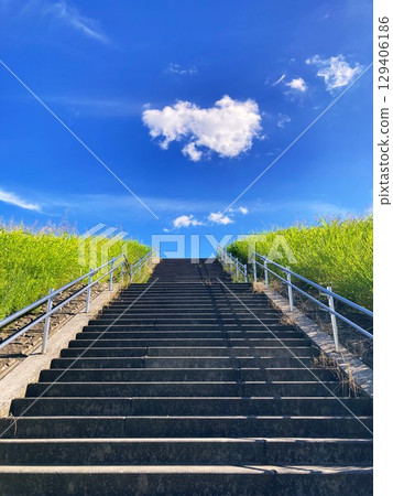 Climbing the stairs on the bank, you will see the blue summer sky and white clouds. Climbing the stairs on the bank, you will see the blue summer sky and white clouds. 129406186