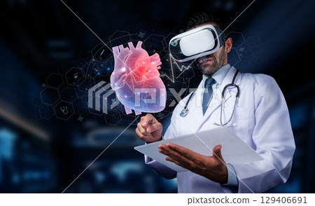 Doctor wearing virtual reality headset examines holographic heart model in medical technology, healthcare innovation and futuristic medical visualization.. PHMT 129406691