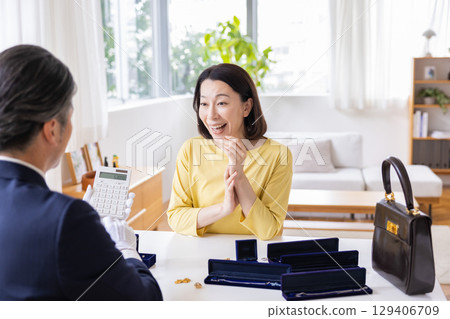現場購買:一位家庭主婦正在家中評估她的物品 現場購買:一位家庭主婦正在家中評估她的物品 129406709