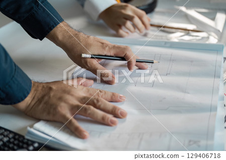 Engineer and architect reviewing blueprint plans in an office environment for innovative design concepts Engineer and architect reviewing blueprint plans in an office environment for innovative design concepts 129406718