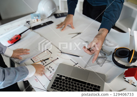 Engineers and architects collaborate on blueprint designs in modern office environment with innovative ideas 129406733