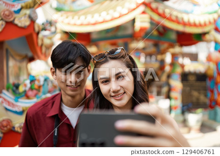 Joyful Travelers Celebrating Chinese New Year with Festive Lanterns and Traditional Decorations in Vibrant Urban Setting Joyful Travelers Celebrating Chinese New Year with Festive Lanterns and Traditional Decorations in Vibrant Urban Setting 129406761