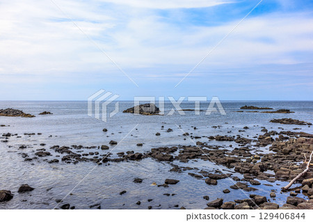 Cape Ogon, Hokkaido. A quiet summer afternoon, with waves lapping under a cloudy sky. 129406844