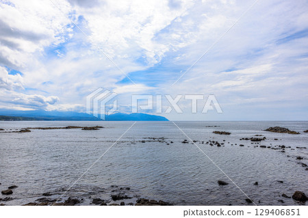 北海道黃金岬。一個寧靜的夏日午後,多雲的天空下,海浪拍打著海岸。 北海道黃金岬。一個寧靜的夏日午後,多雲的天空下,海浪拍打著海岸。 129406851