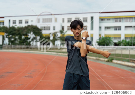 Athlete stretching routine track field sports urban environment close-up fitness and health awareness Athlete stretching routine track field sports urban environment close-up fitness and health awareness 129406963