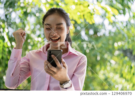 Celebrating success outdoor park candid shot lush greenery joyful woman achievement in nature Celebrating success outdoor park candid shot lush greenery joyful woman achievement in nature 129406970