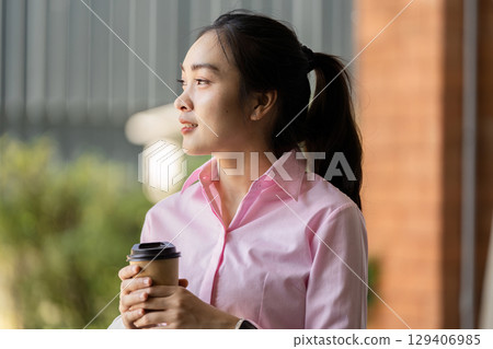 Young woman enjoys coffee while reflecting outdoors in urban setting captivating lifestyle moment Young woman enjoys coffee while reflecting outdoors in urban setting captivating lifestyle moment 129406985