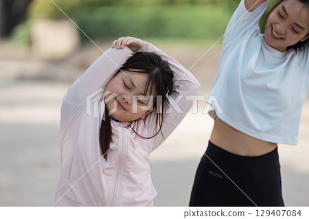 Mother and Daughter Enjoying Outdoor Exercise Together in a Park on a Sunny Day, Promoting Healthy Lifestyle and Family Bonding Through Physical Activity 129407084