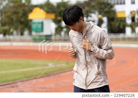 Young Man Jogging on Track Promoting Health and Fitness in Outdoor Setting for Wellness and Active Lifestyle Young Man Jogging on Track Promoting Health and Fitness in Outdoor Setting for Wellness and Active Lifestyle 129407226