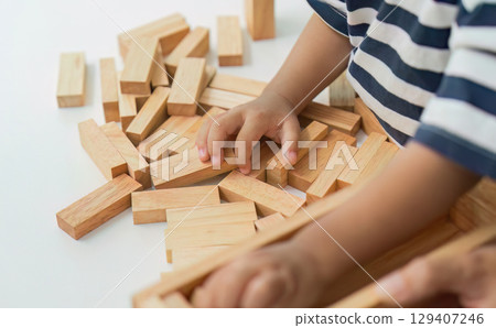Child Development. Close-up of toddler's hands playing with wooden blocks. 129407246