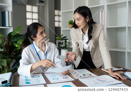 Professional Businesswomen collaboration in Modern Office Environment with Laptop and Documents Professional Businesswomen collaboration in Modern Office Environment with Laptop and Documents 129407433