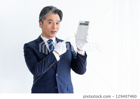 買家估價師,戴著白手套,拿著計算器的男人 買家估價師,戴著白手套,拿著計算器的男人 129407460