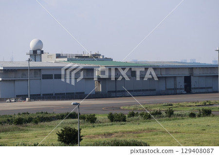 A view of the airport with sky, green space and factories 129408087
