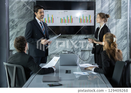 Business professionals in modern conference room presenting data charts during a meeting, discussing strategies and analyzing performance for corporate growth and success. Business professionals in modern conference room presenting data charts during a meeting, discussing strategies and analyzing performance for corporate growth and success. 129409268
