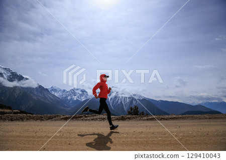 Woman trail runner cross country running at high altitude mountains Woman trail runner cross country running at high altitude mountains 129410043