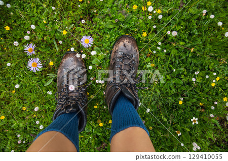 Hiker legs walking on beautiful flowering grassland 129410055