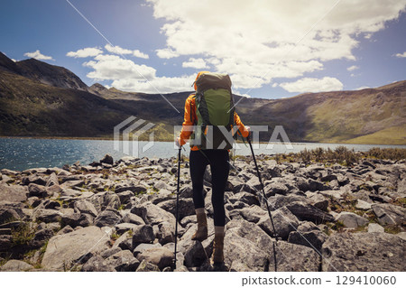 Woman hiking on high altitude mountains, walking to a beautiful lake Woman hiking on high altitude mountains, walking to a beautiful lake 129410060