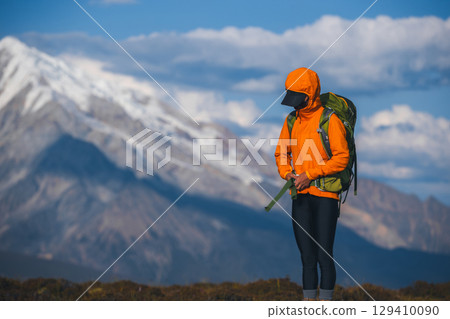 Woman hiking on sunset high altitude mountain top 129410090
