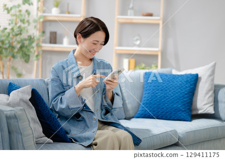 Middle woman looking at smartphone Middle woman looking at smartphone 129411175