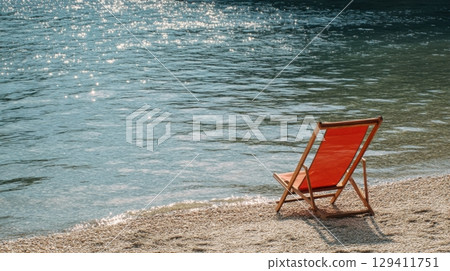 serene beach scene with empty red deck chair 129411751