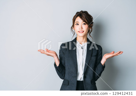 張開雙臂的女性商務人士 | 擺出解釋或指導姿勢的人的圖片 129412431