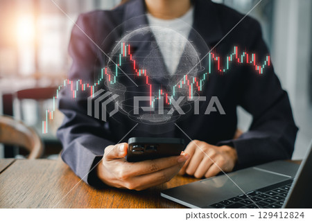 A business professional examines forex market trends using a smartphone and laptop, symbolizing global finance and trading. A business professional examines forex market trends using a smartphone and laptop, symbolizing global finance and trading. 129412824