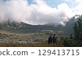 Hikers admiring breathtaking mountain view with clouds and lake 129413715
