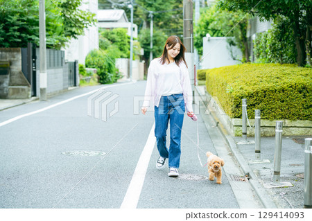 Young woman walking with pet 129414093