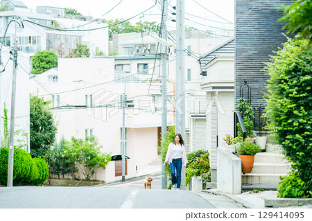 Young woman walking with pet 129414095
