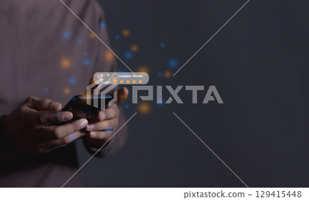 Review Customer, Young Man hand holding Smart Phone with five star to review and give 5 stars  129415448