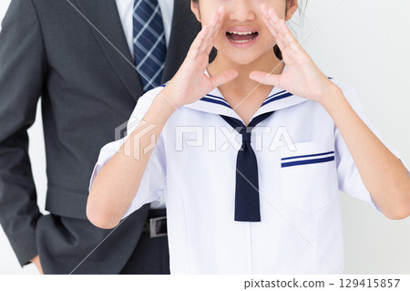 一名身穿夏季校服的中學生在歡呼，她的父親則穿著西裝 129415857