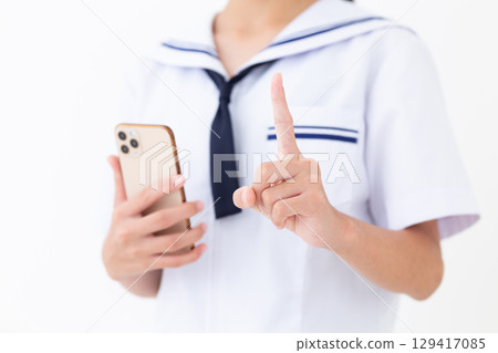 一名身穿夏季校服的國中女生拿著智慧型手機，食指向上 129417085