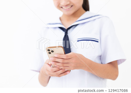 一名身穿夏季校服的國中女生拿著智慧型手機 129417086