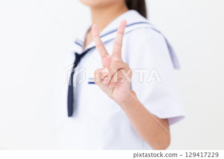 一名身穿夏季校服的國中女生做出和平手勢 129417229