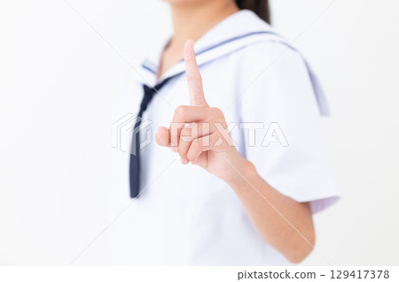 一名身穿夏季校服的國中女生舉起食指 一名身穿夏季校服的國中女生舉起食指 129417378