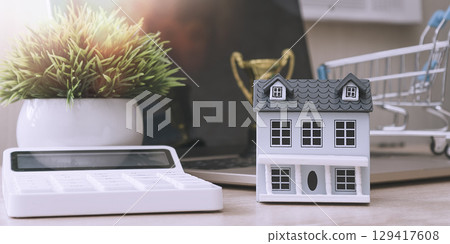 Mini house with calculator and shopping cart Mini house with calculator and shopping cart 129417608