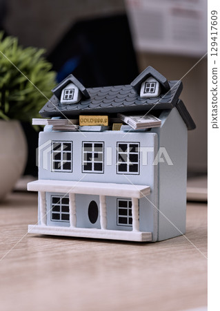 Mini house with cash and gold inside roof 129417609